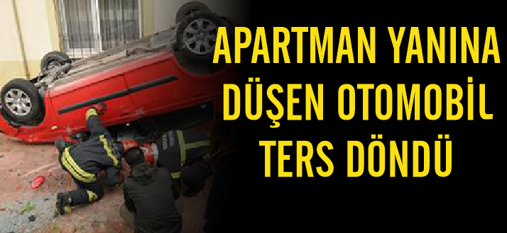 Apartman yanına düşen otomobil ters döndü